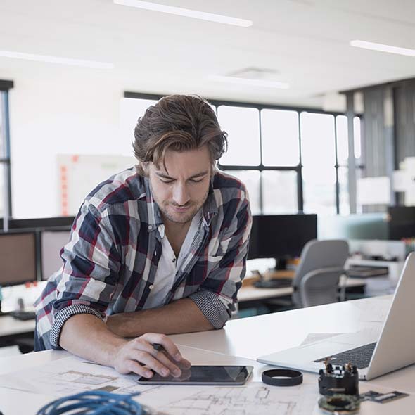 Web developer working on his tablet in his office