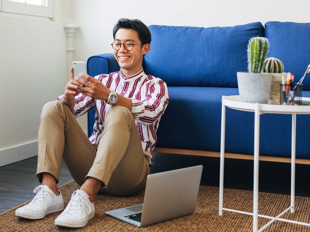 man sitting on floor texting